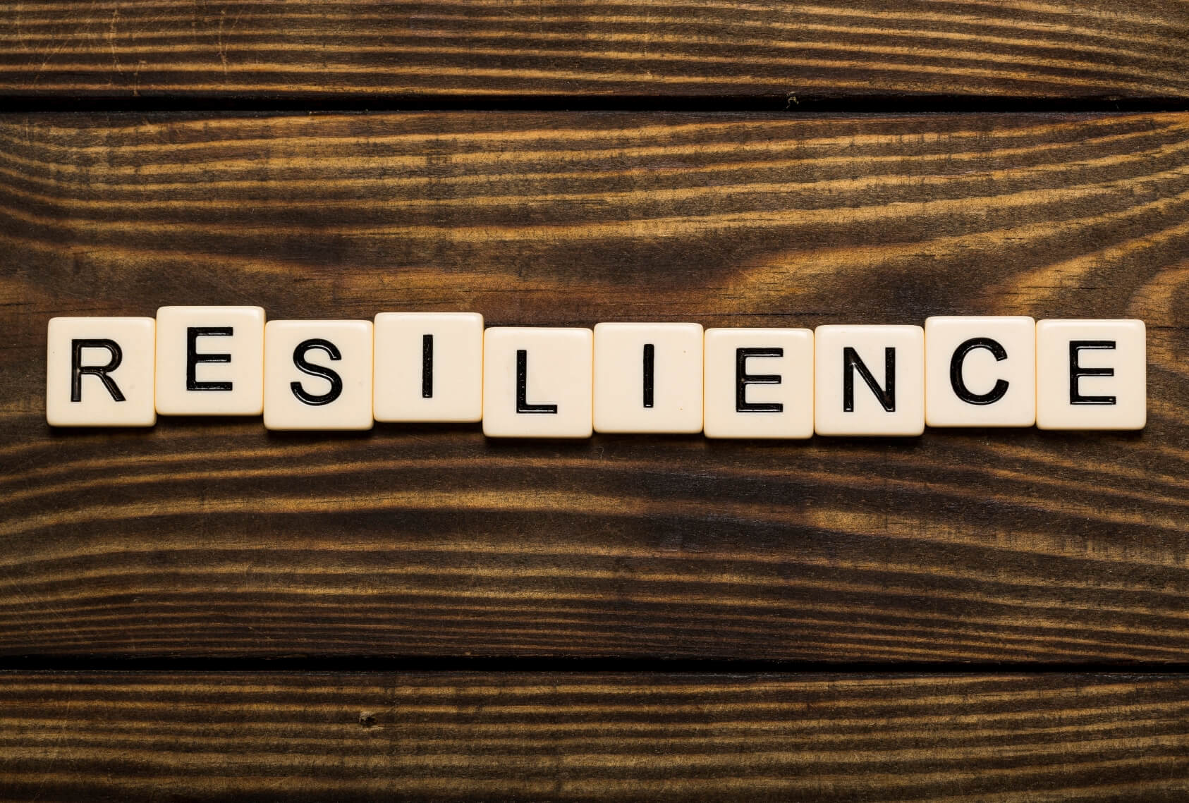 Business man pointing to transparent board with text: Resilience