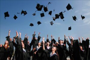 Graduating class throwing their graduation caps up in the air