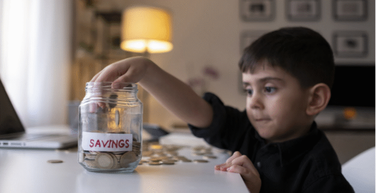 Child reaching into a jar of savings, illustrating the importance of financial literacy for youth
