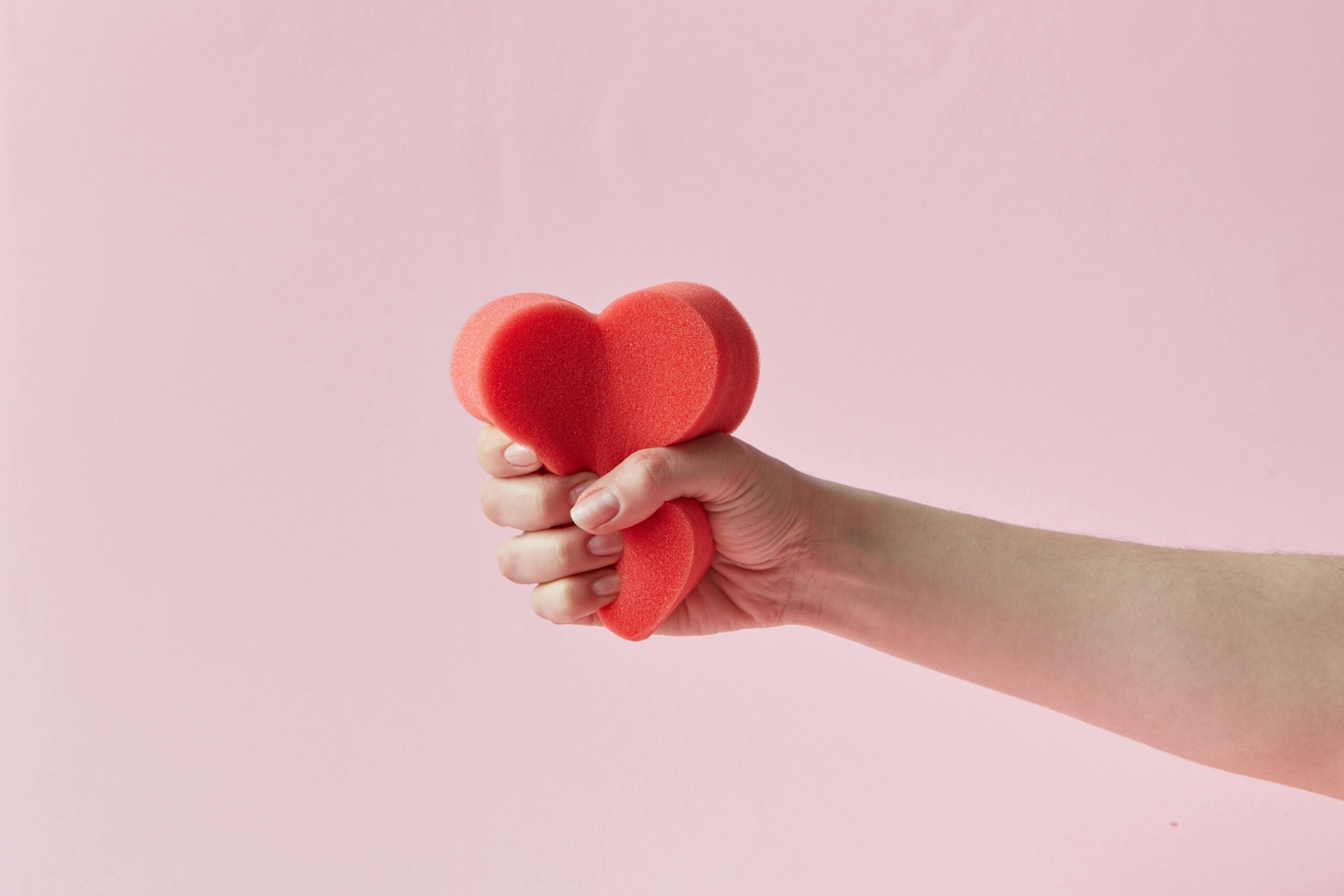 Person squeezing a heart shaped sponge